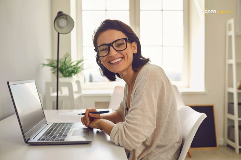 Smiling woman using a laptop, representing online security and privacy concerns related to Google Recaptcha cookies and GDPR compliance.